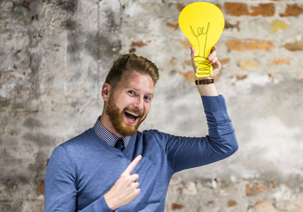 Businessman holding up a yellow lightbulb