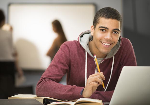 Male student sitting at laptop